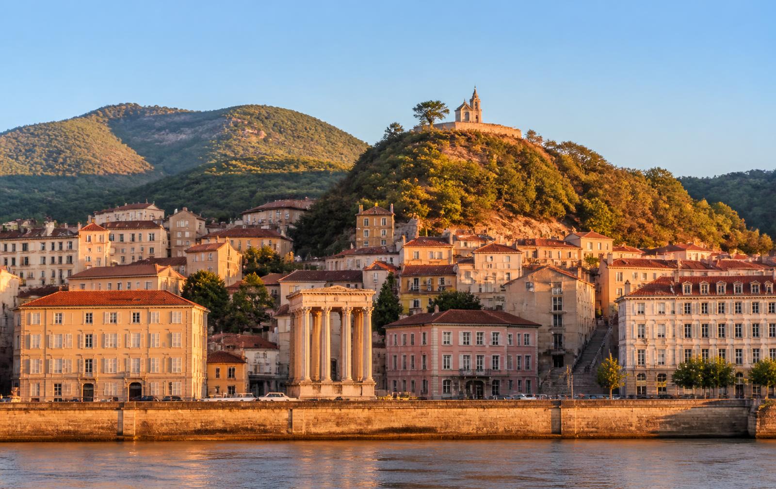 Vienne (Isère) au bord du Rhône : temple d'Auguste et Livie, toits de la vieille ville et colline de Pipet au coucher du soleil